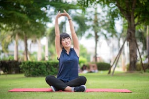 Hermosa mujer del yoga en el parque verde