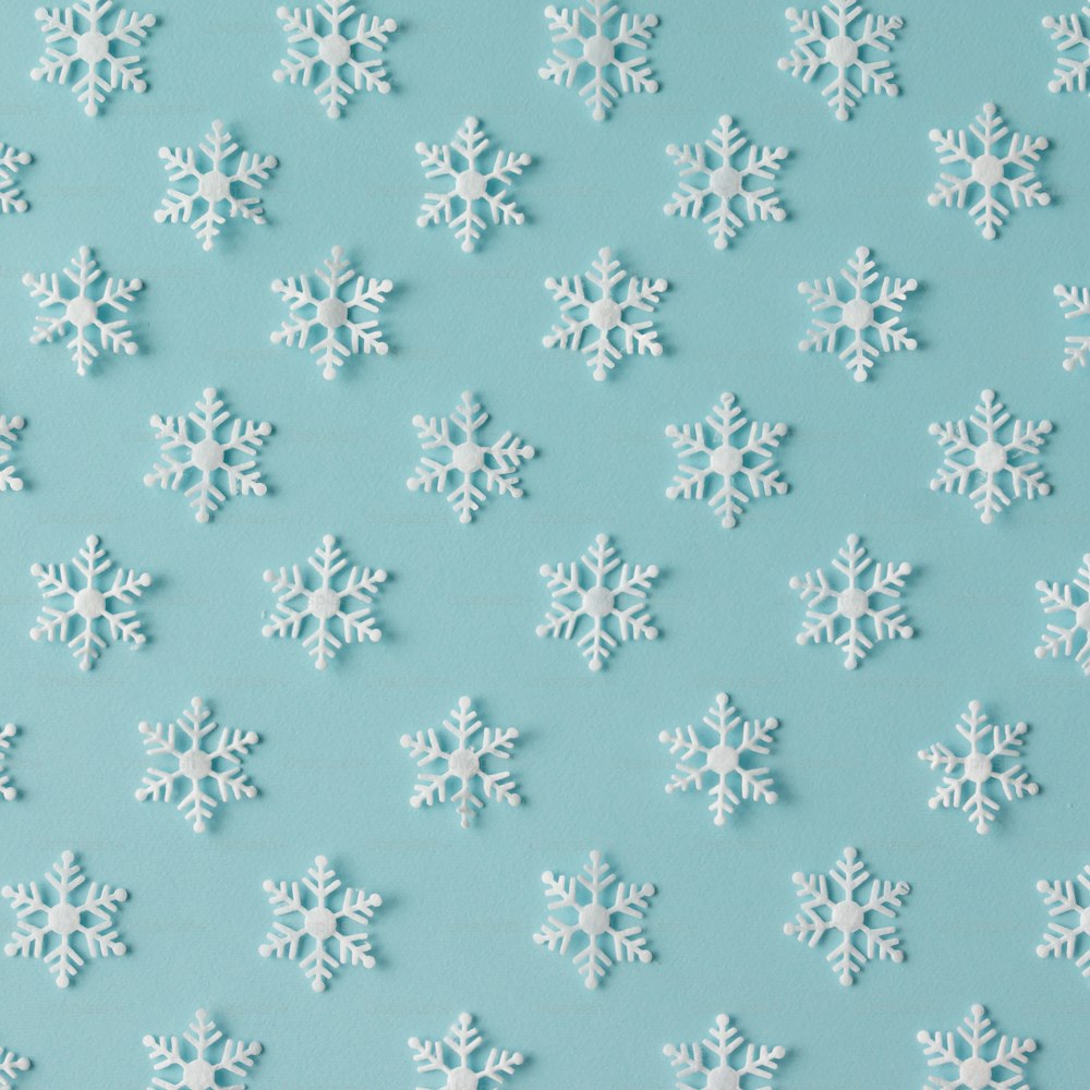 Patrón invernal hecho de copos de nieve sobre fondo azul. Concepto de invierno. Plano tendido.