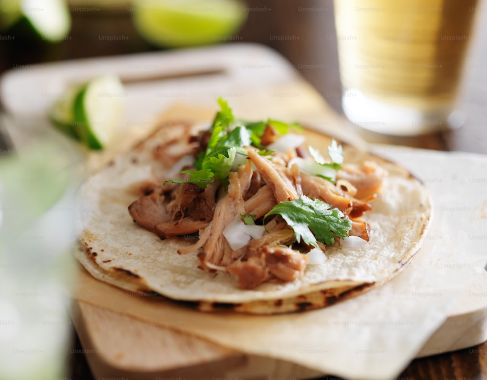 autentici tacos messicani con carnitas, coriandolo e cipolla e birra in sottofondo