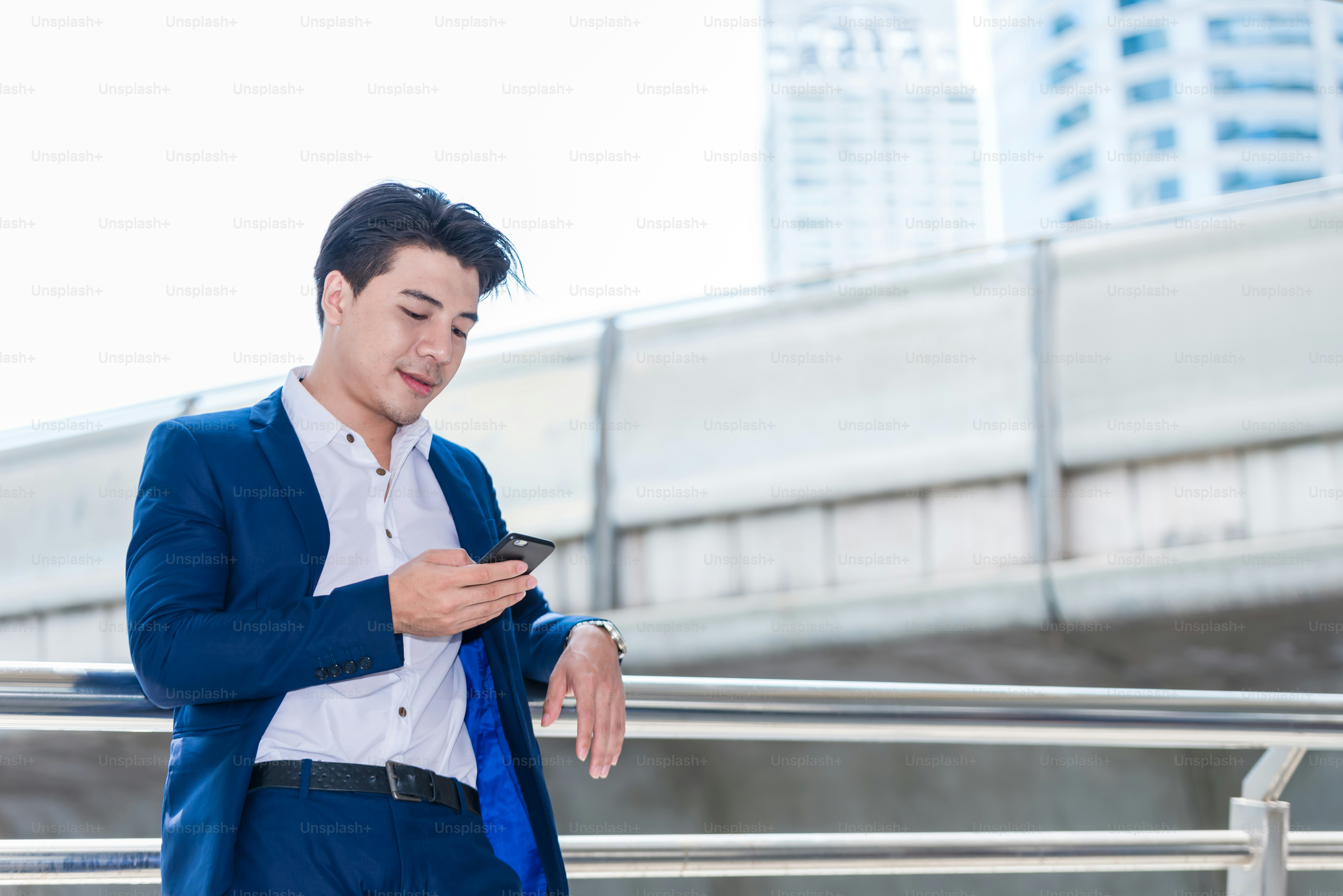 Asian business man talking reading his smart phone.