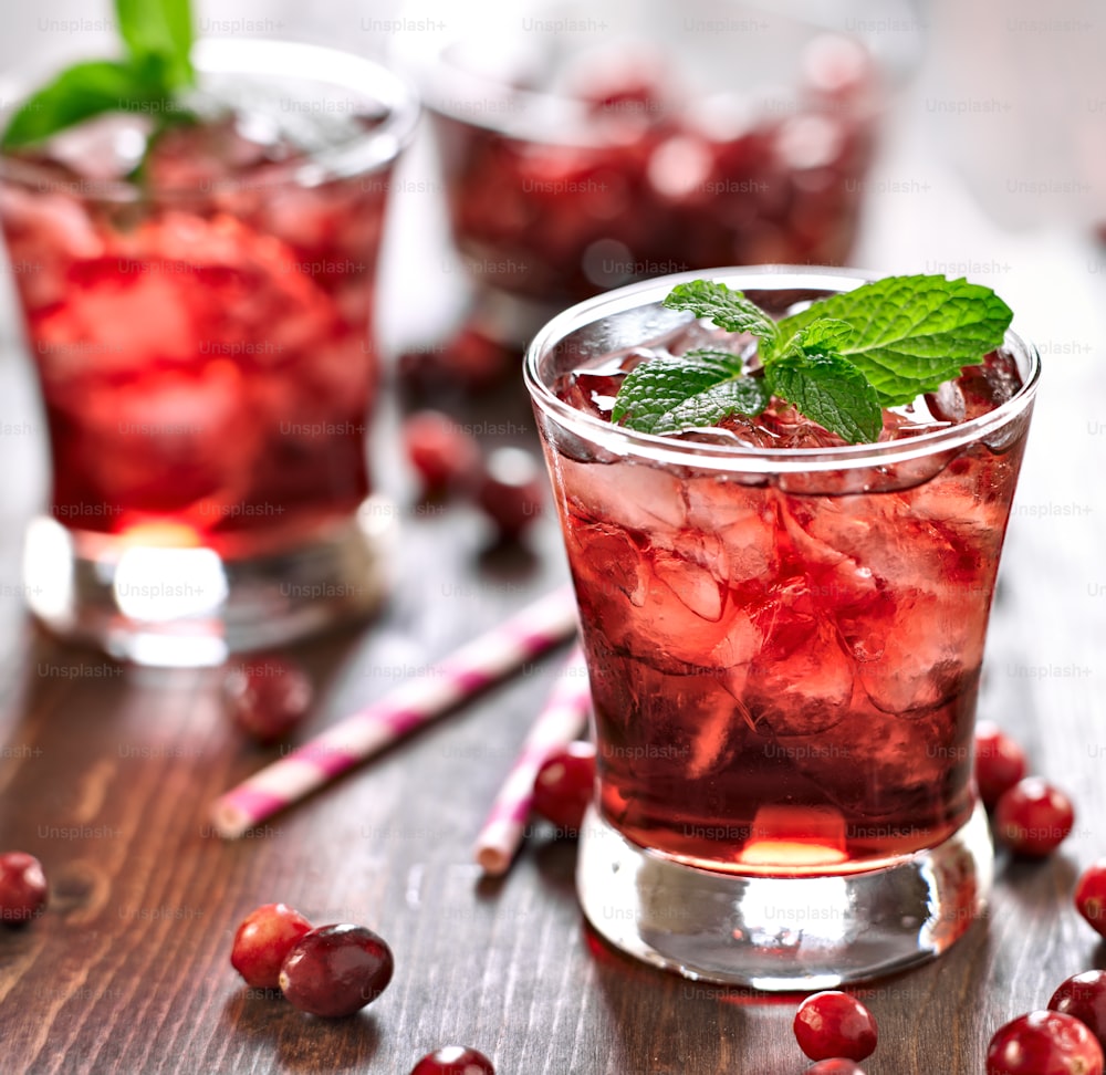 close up photo of a cranberry cocktail with mint garnish.