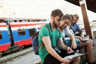 Young group of travelling tourists at train station