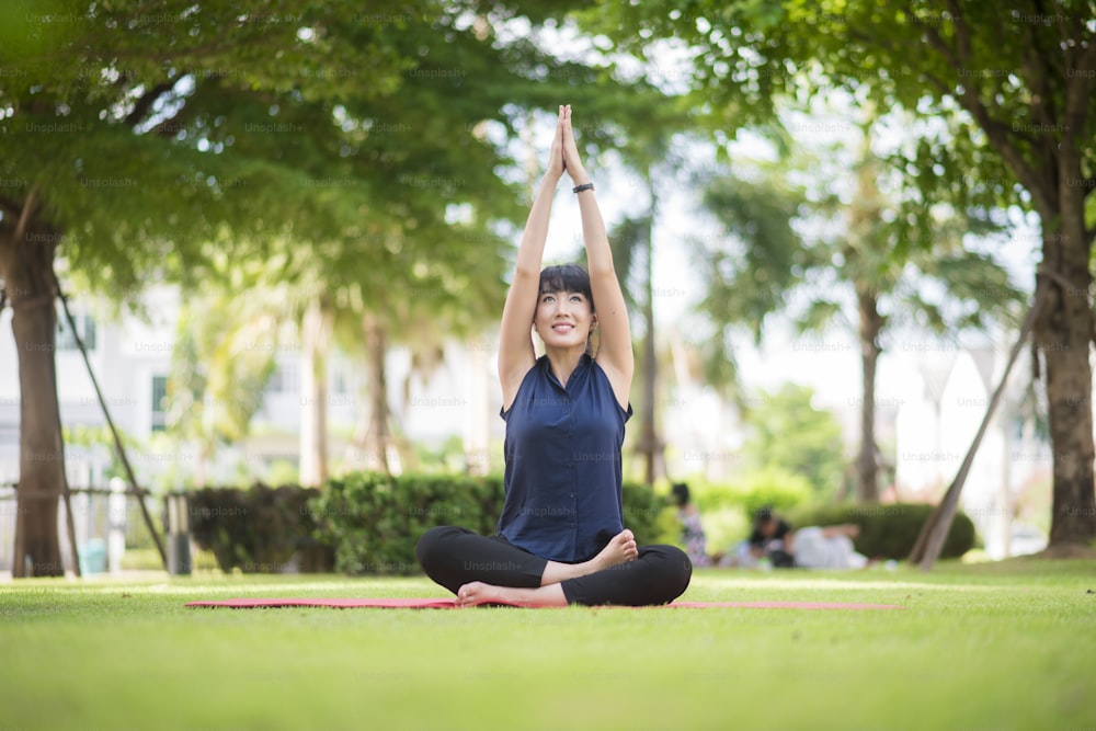 Beautiful yoga woman on green park