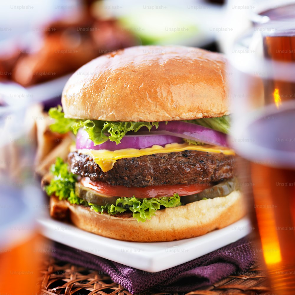 burger with beer glasses and barbecue chicken wings, shot with selective focus