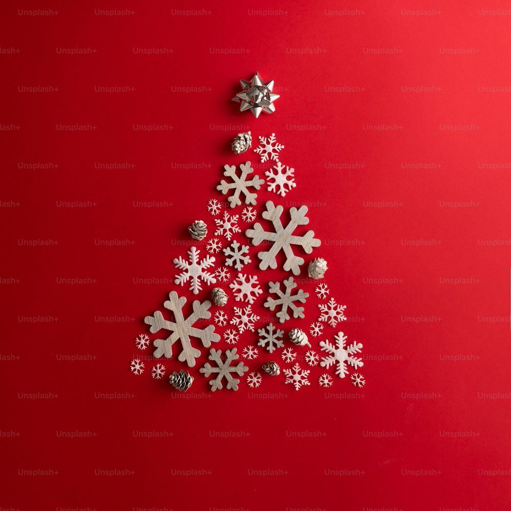 Christmas and New Years red background with Christmas Tree made of snowflakes. Holiday concept. Flat lay.