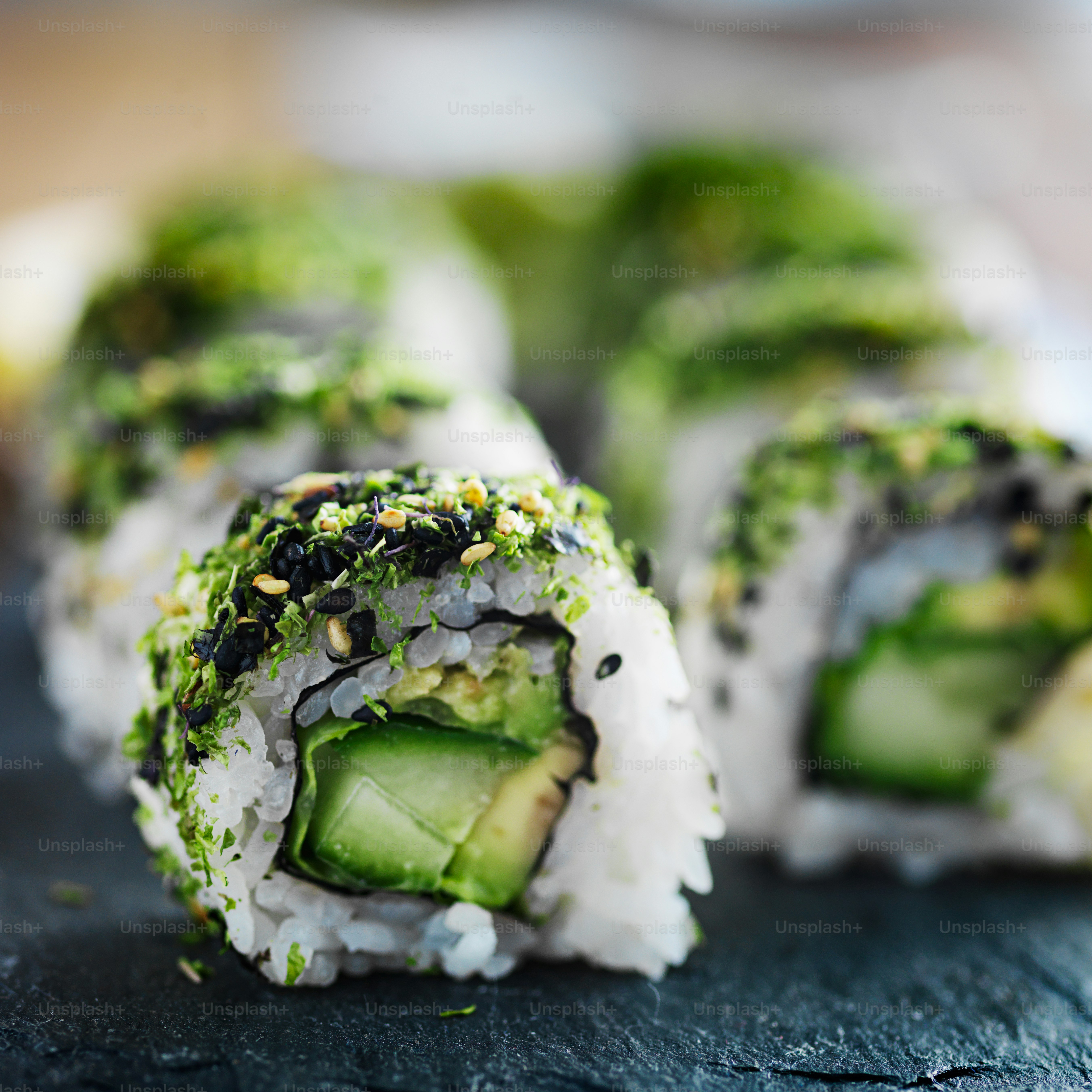healthy green kale and avocado sushi roll on slate close up