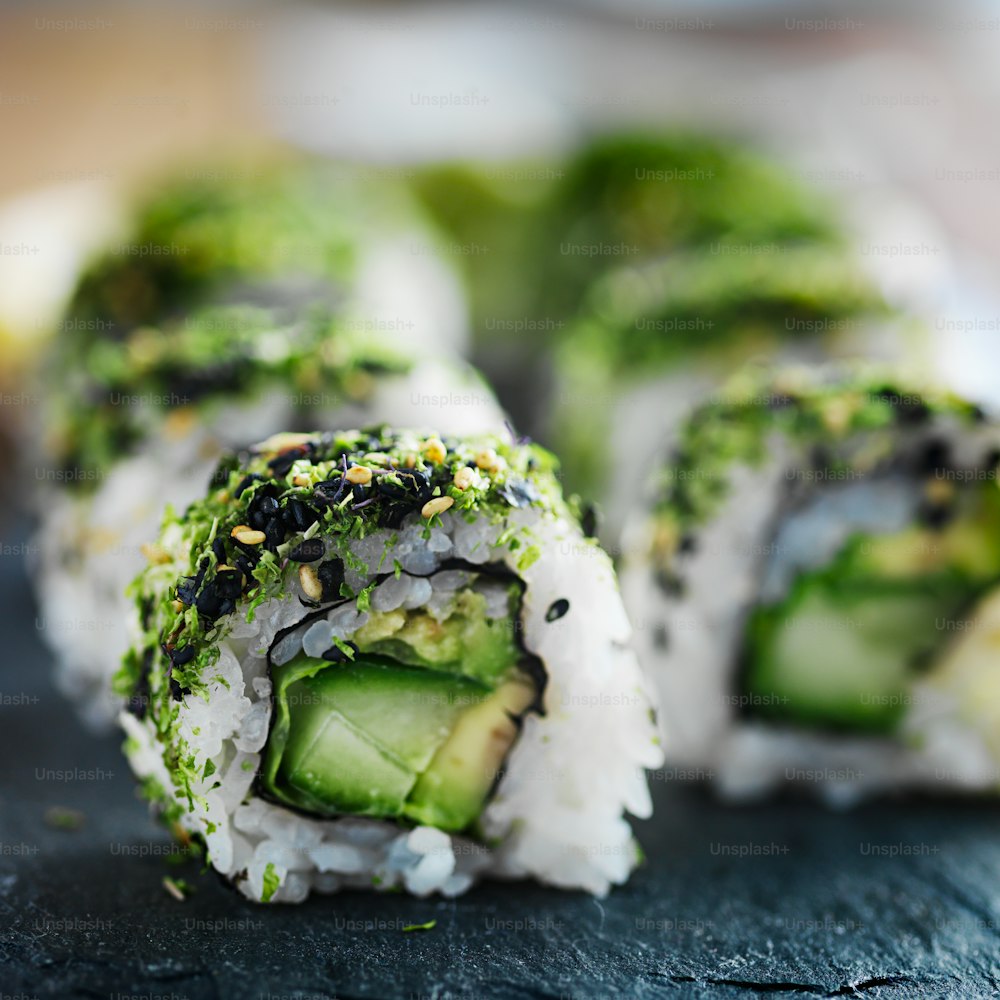 healthy green kale and avocado sushi roll on slate close up