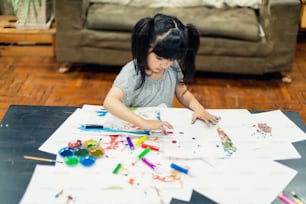 felicidad niño caucásico juego divertido pintar crayón en papel cancas en la sala de estar