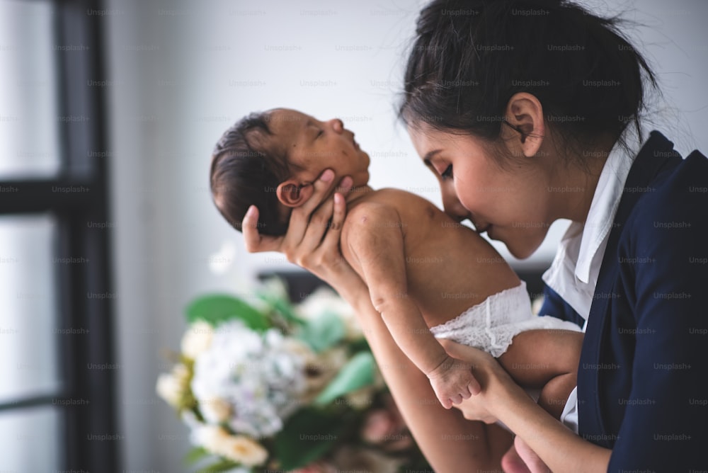 businesswoman is working by holding her baby