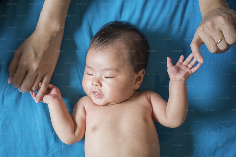 Nahaufnahme der neugeborenen Hand in der Hand der Mutter im Schlaf