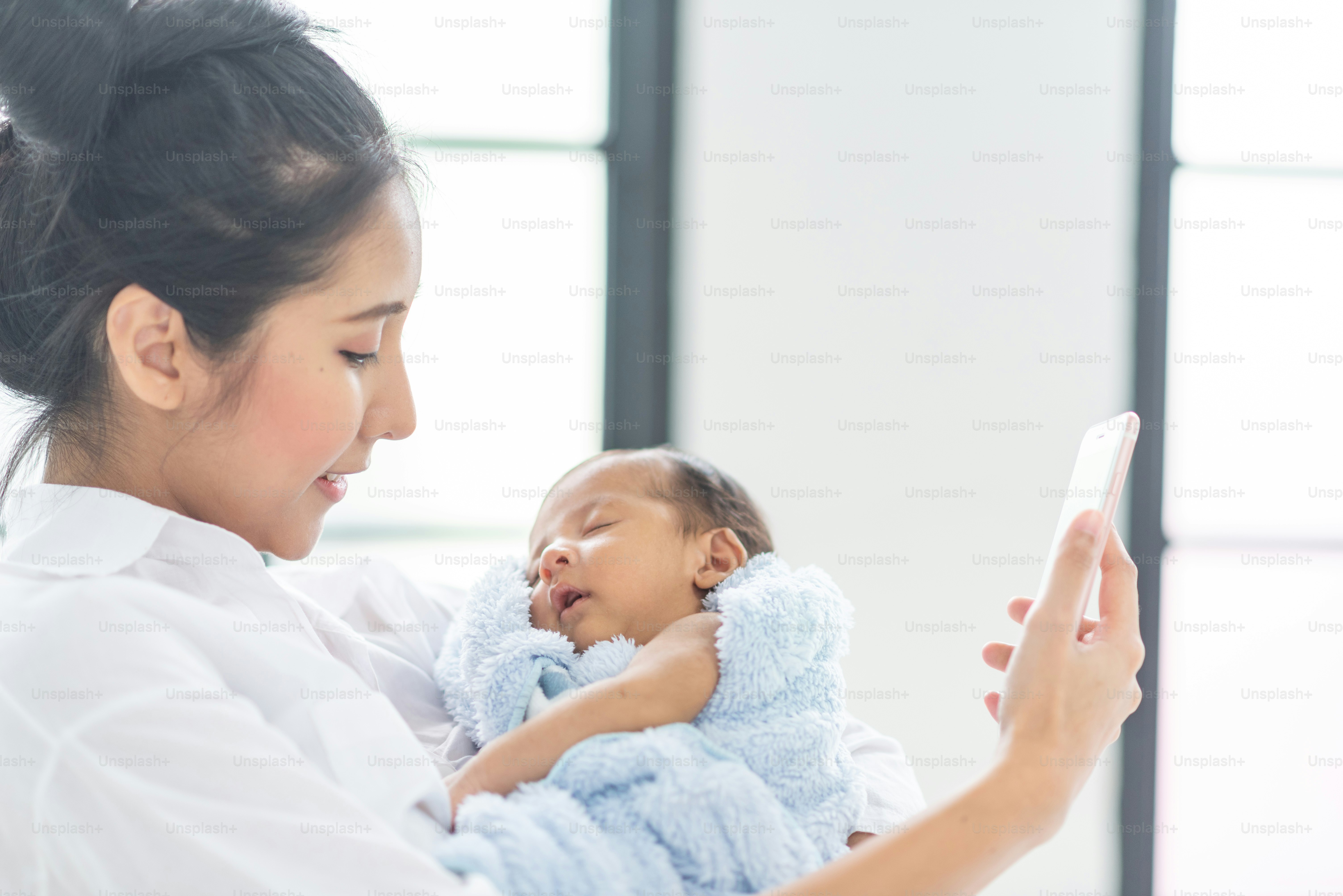A young mother carries a baby