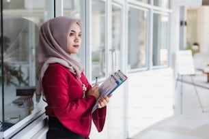 Young asian muslim woman teacher holding documents and learning plan.