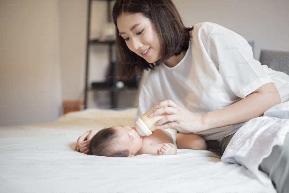 Una niña recién nacida está bebiendo leche por su madre