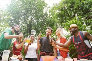 Group of friends toasting beers outdoors. Party people drinks toast celebration.