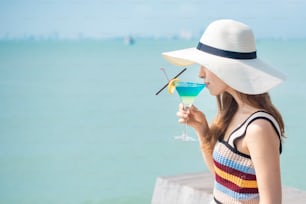 Schöne Frau trinkt Eissommergetränk am Strand, Sommerkonzept