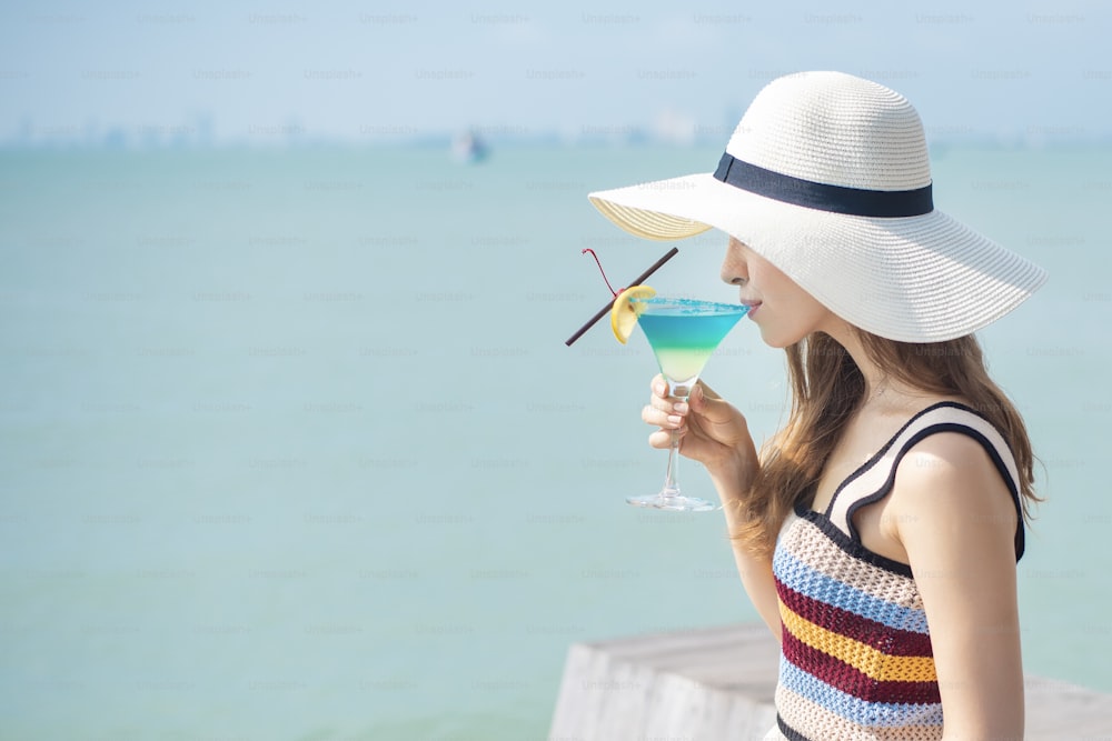 아름다운 여자는 해변에서 얼음 여름 음료를 마시고 있다, 여름 개념