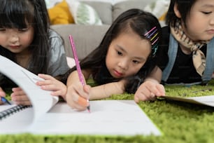 Group of little preschool kids drawing paper with color pencils . portrait of children friends education concept.