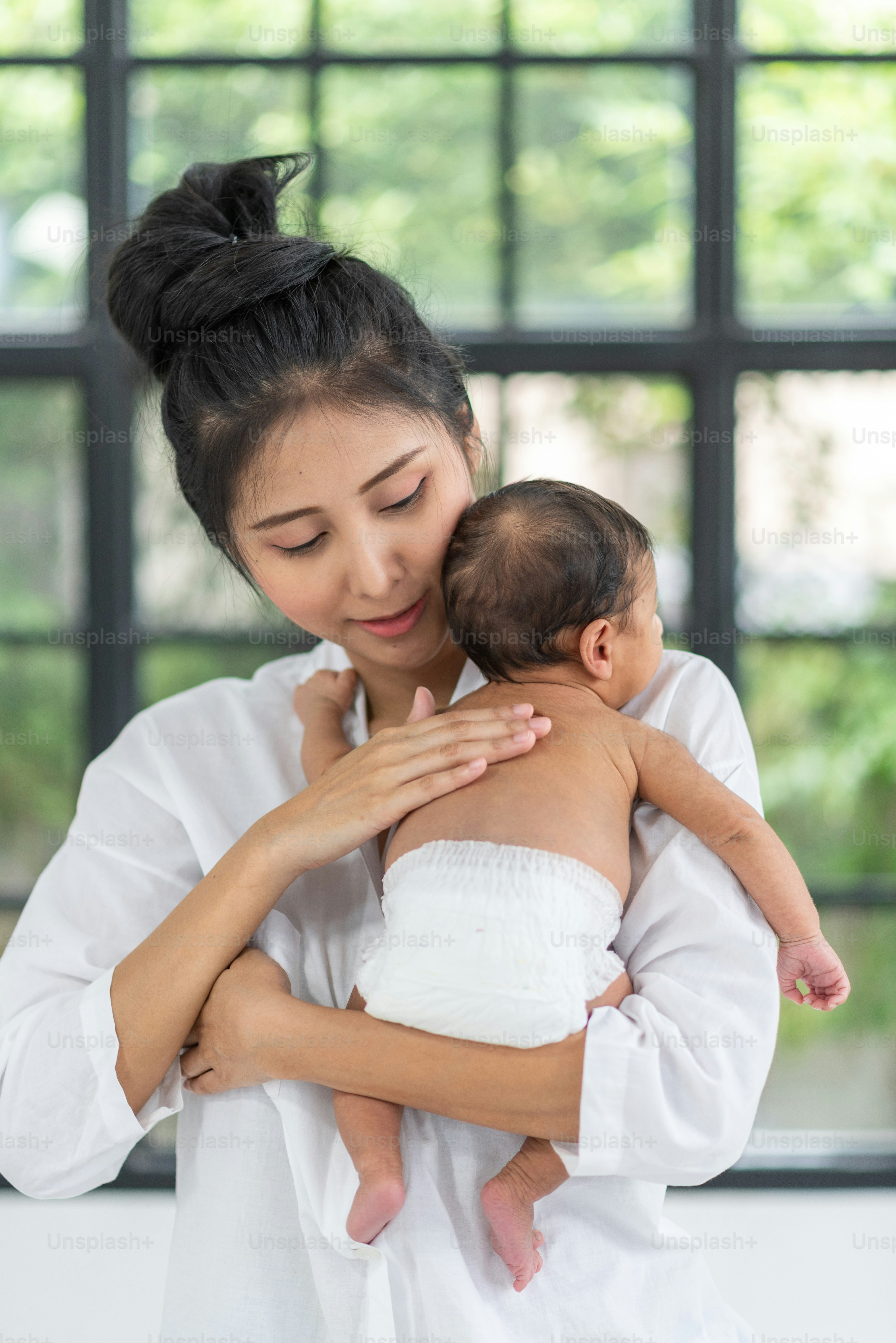 A young mother carries a baby
