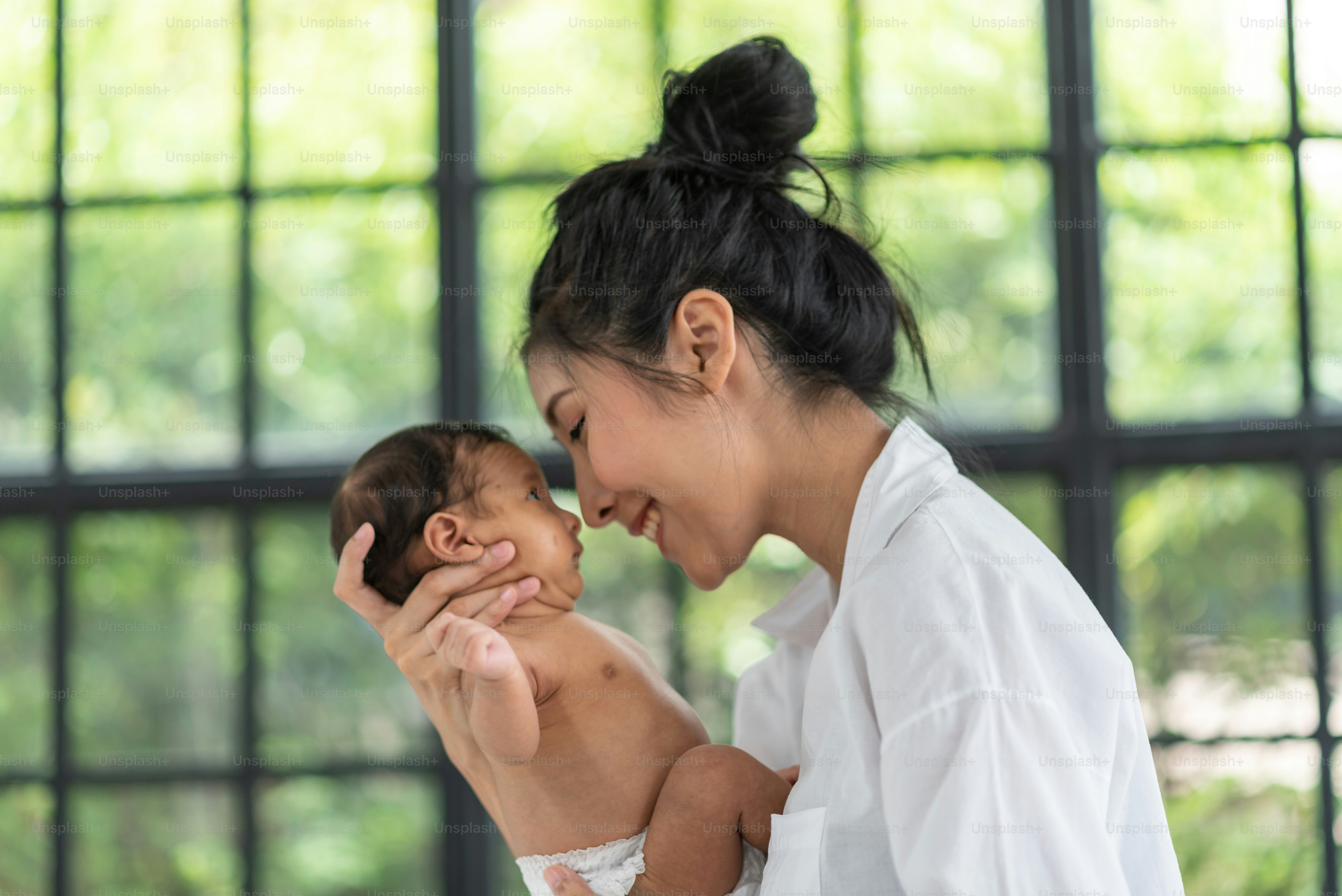A young mother carries a baby