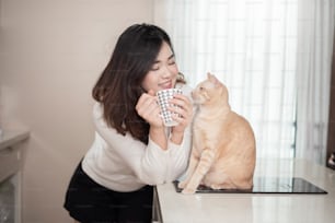 Beautiful asian  cat lover woman is playing with cat in her room