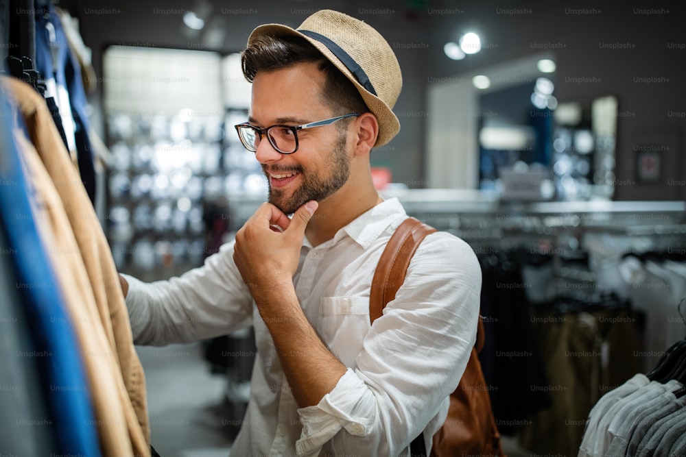 Portrait of a handsome young man shopping for clothes at shop