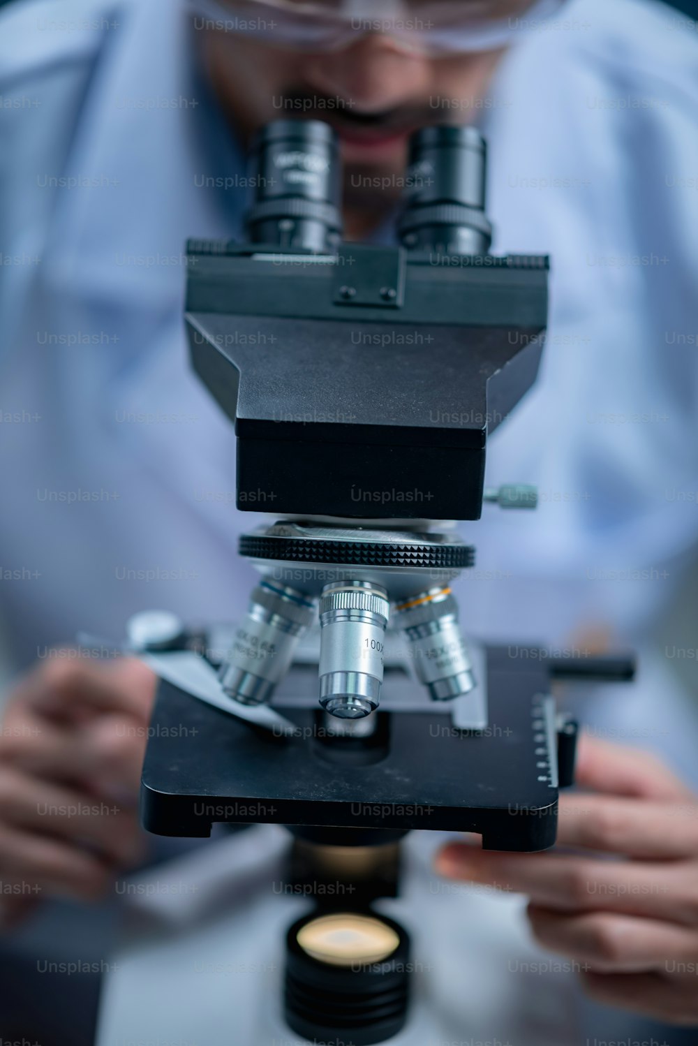 Joven científico mirando a través de un microscopio en un laboratorio. Joven científico haciendo algo de investigación.