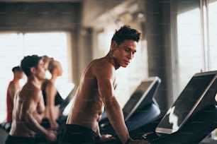 Muscular bodybuilder guy doing exercises  in gym