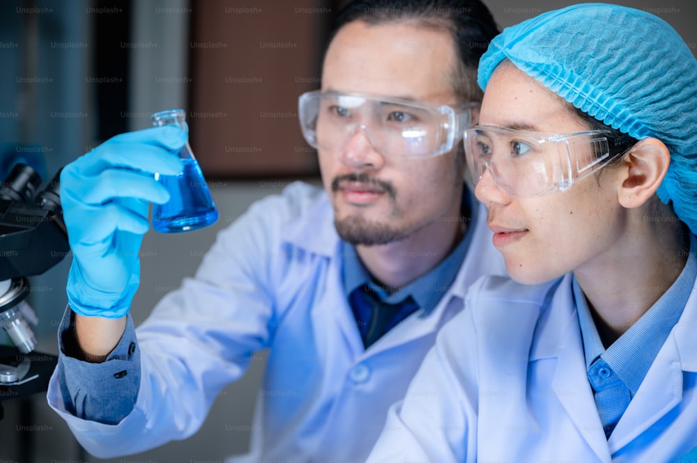科学と医学、科学者がサンプルを分析してガラス器具に落とす、ガラス器具、DNA構造、革新的および技術に関する実験室での化学液体を含む実験。