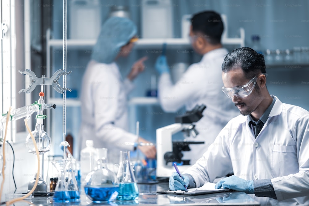 In un laboratorio moderno il team di scienziati conduce esperimenti, costituiti da provette e microscopi di vetreria