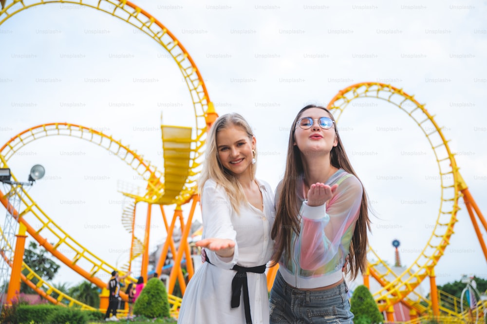 Friends group relaxing at an amusement theme park, concept of happy and hangout carnival