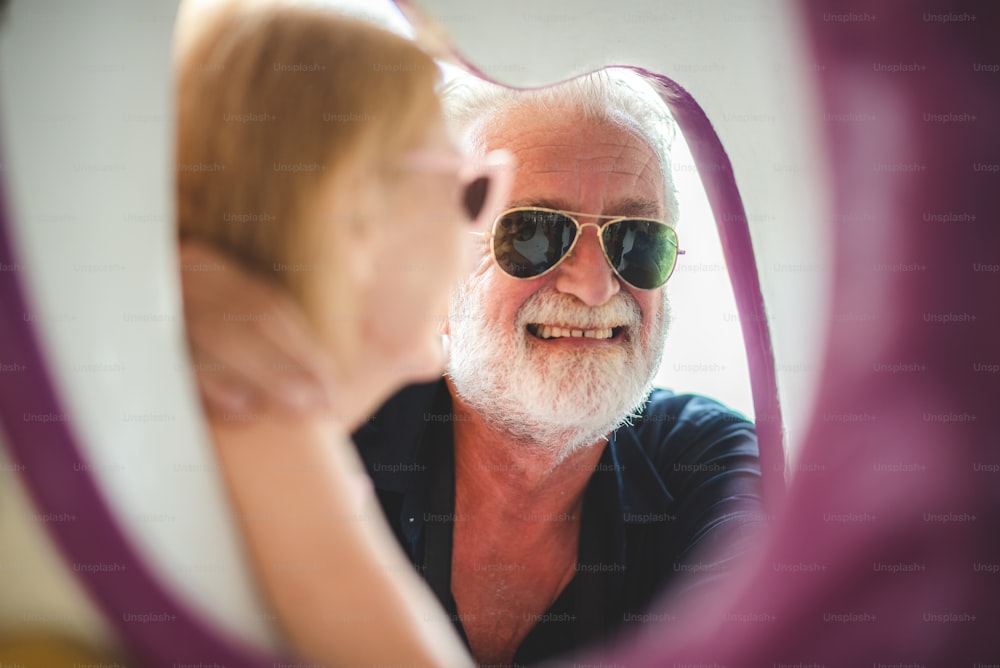 Senior couple enjoying and happy to travel and playing at an amusement theme park, concept of love and happy with old 60's senior people