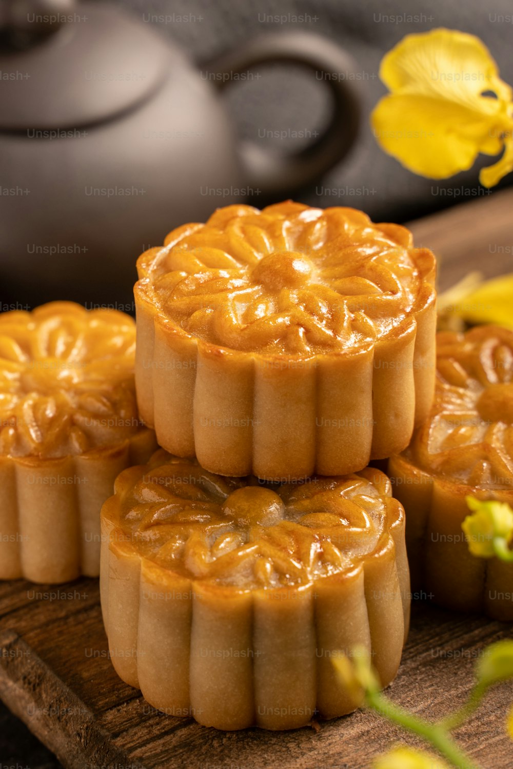 Mooncake, Moon cake for Mid-Autumn Festival, concept of traditional festive food on black slate table with tea and yellow flower, close up, copy space.
