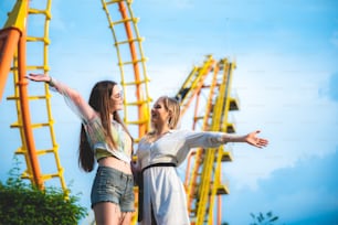 Friends group relaxing at an amusement theme park, concept of happy and hangout carnival