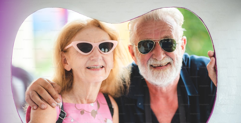 Seniorenpaar, das es genießt und glücklich ist, in einem Vergnügungspark zu reisen und zu spielen, Konzept der Liebe und glücklich mit alten 60er Jahren Senioren