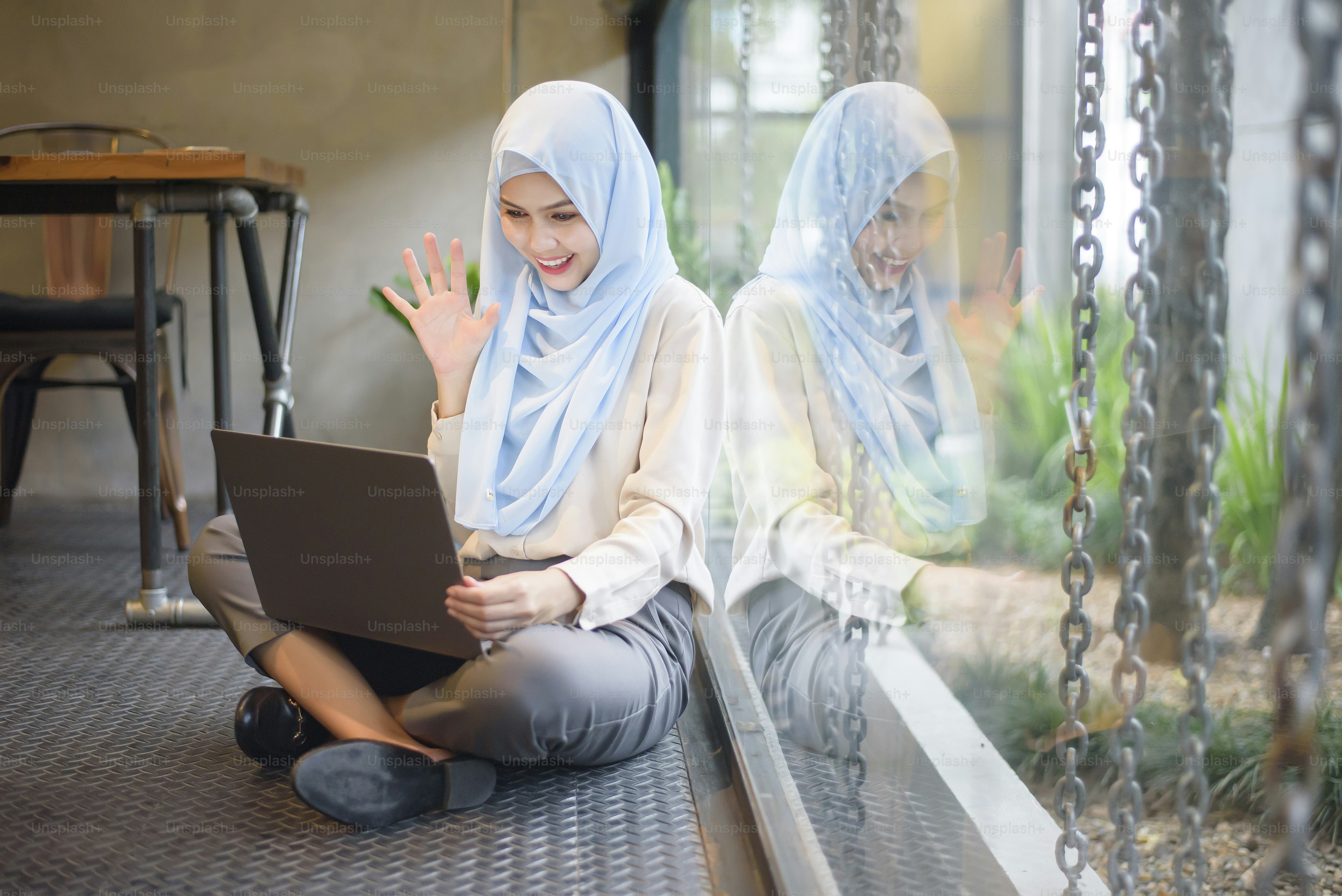 Muslim woman with hijab is working with laptop computer in coffee shop ...