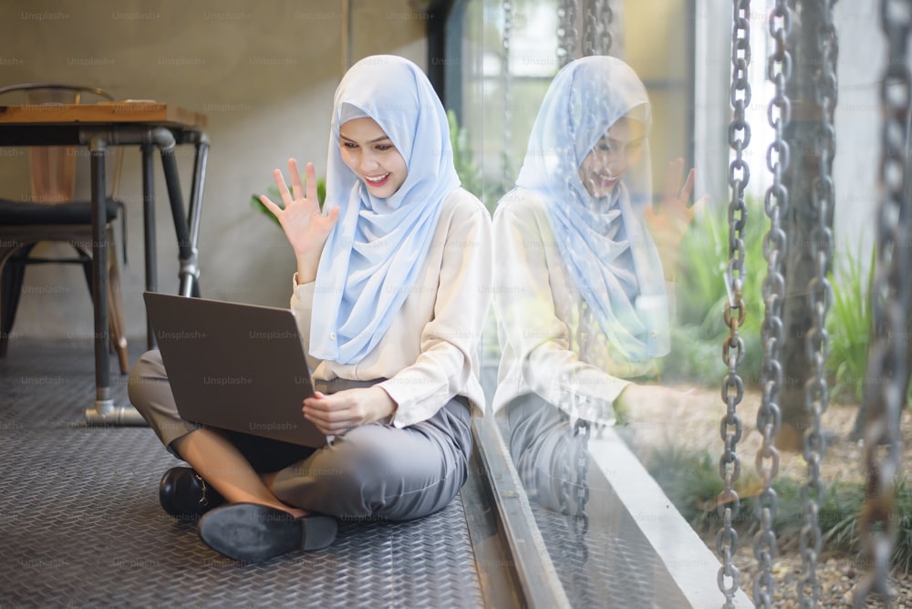 Muslim woman with hijab is working with laptop computer in coffee shop