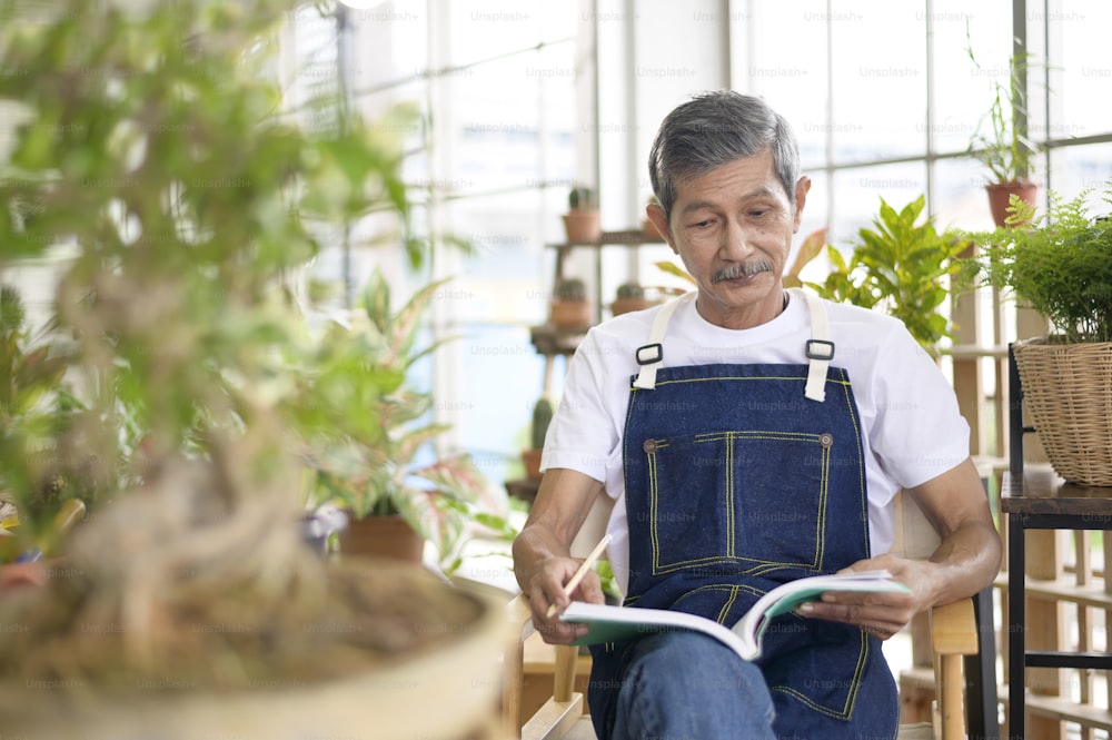 A happy senior asian retired man reading and enjoying  leisure activity in garden at home.