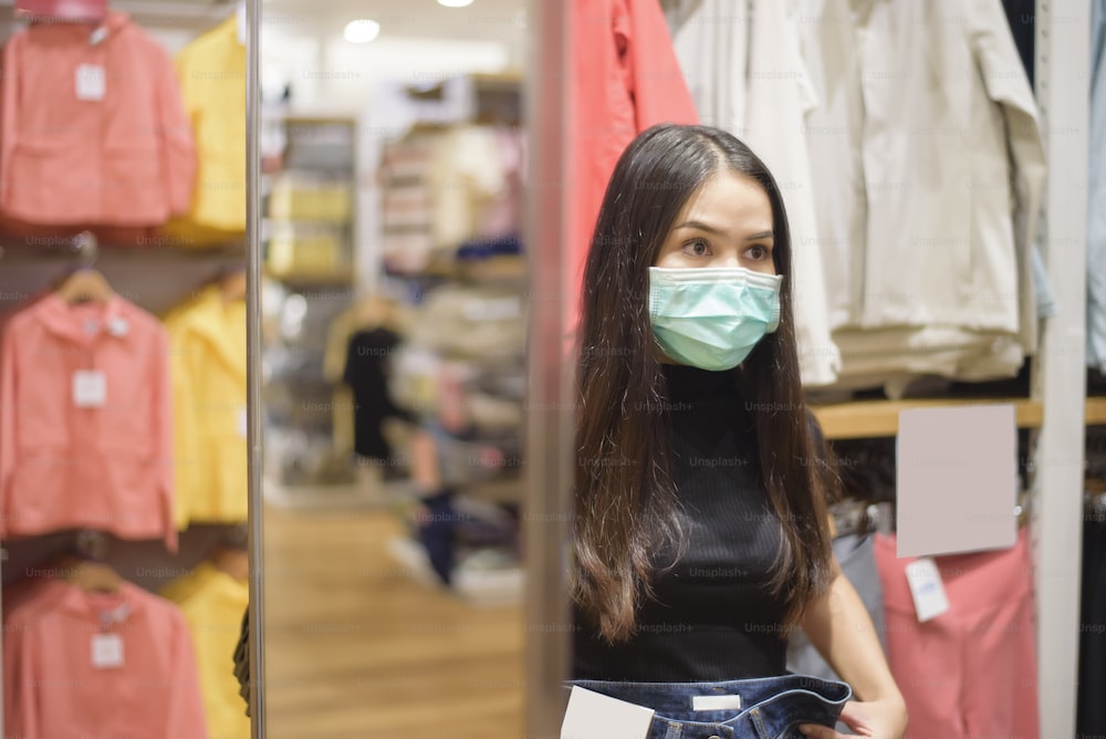 woman with face mask is shopping clothes in Shopping center