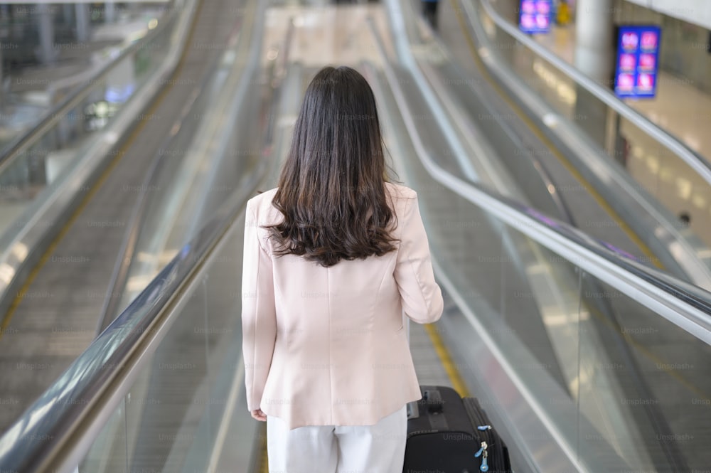 Una mujer de negocios usa una máscara protectora en el aeropuerto internacional, viaja bajo la pandemia de Covid-19, viajes de seguridad, protocolo de distanciamiento social, concepto de viaje de nueva normalidad.