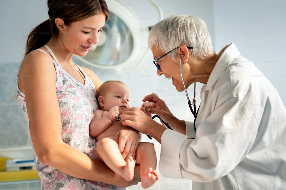 Happy pediatrician doctor examines baby. Healthcare, people, examination concept
