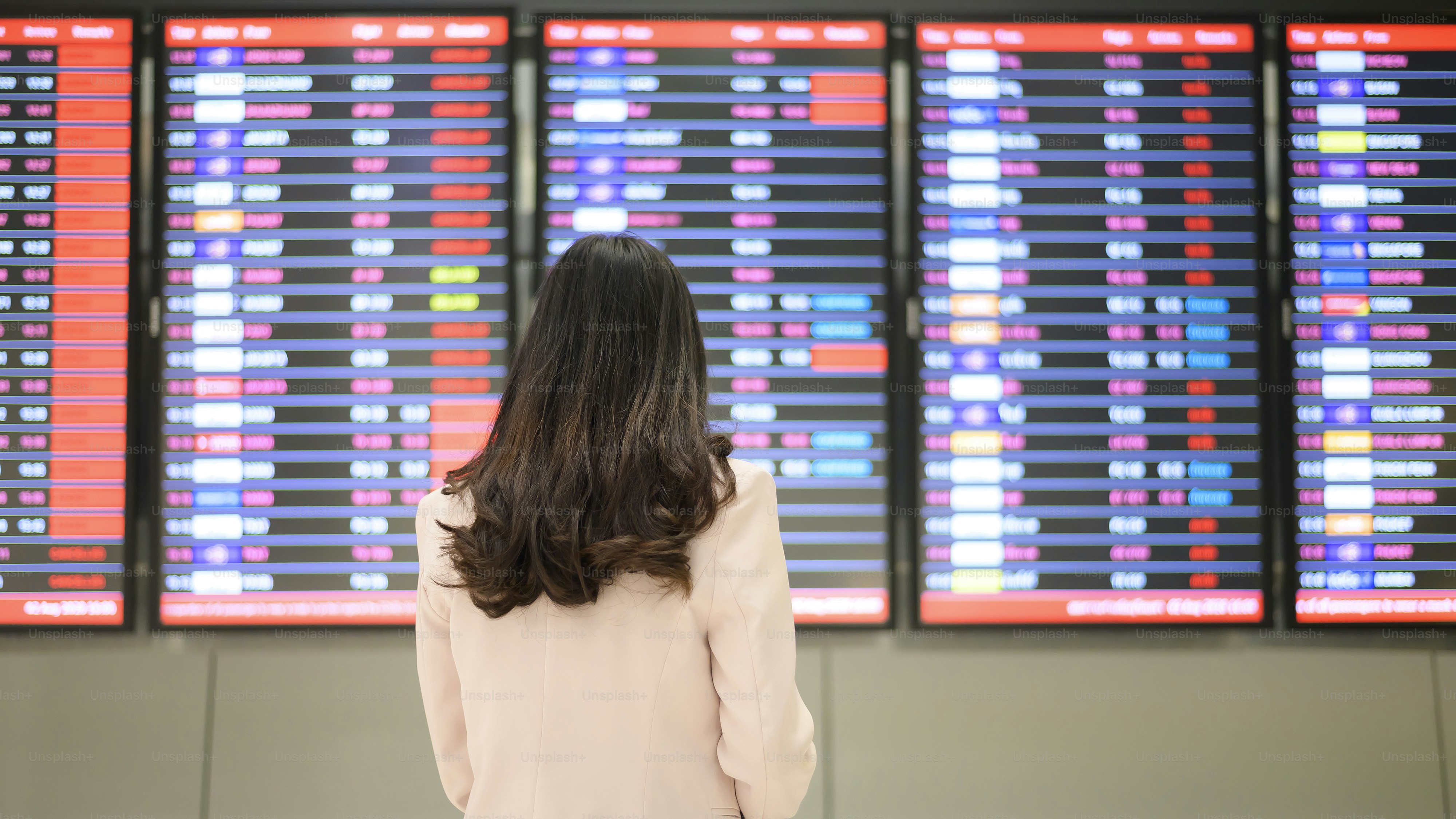 A business woman is wearing protective mask in International airport, travel under Covid-19 pandemic, safety travels, social distancing protocol, New normal travel concept.