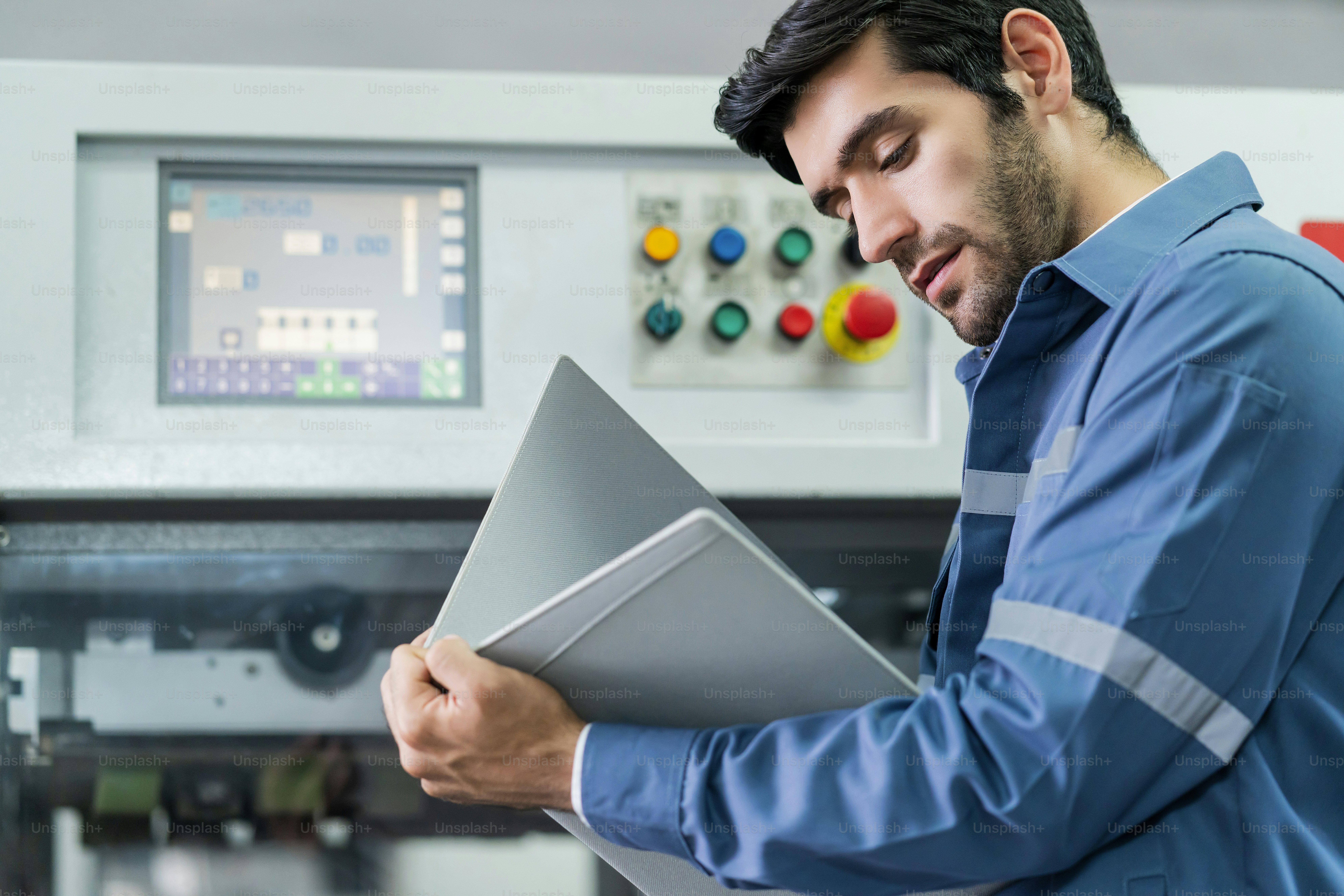 L’ingénieur professionnel caucasien masculin examine la vérification de la progression du système de machines du flux de travail et le résultat du projet dans le contexte de l’usine, le concept industriel et technologique