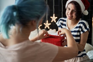 Heureux couple lesbien offrant des cadeaux de Noël
