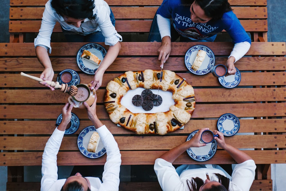 Mexicains mangeant Rosca de reyes ou gâteau de l’Épiphanie, Roscon de reyes avec une tasse de chocolat mexicaine traditionnelle au Mexique vue de dessus