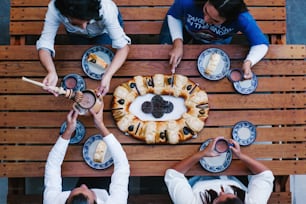 Mexican people eating Rosca de reyes or Epiphany cake, Roscon de reyes with traditional mexican chocolate cup in Mexico top view