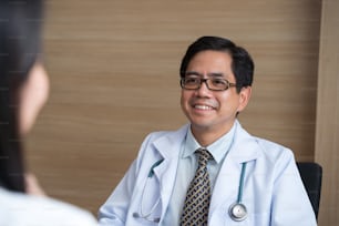 Médico asiático que consulta a un paciente en el hospital