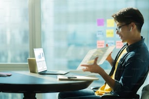 Sorriso positivo intelligente uomo d'affari maschio asiatico videoconferenza lavoro a distanza discutere concersation sulla strategia pianificazione aziendale nuovo concetto di idee di avvio di business, incontro di lavoro online tramite laptop