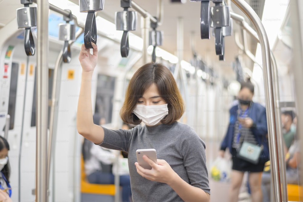 Una mujer joven está usando una máscara protectora en el metro, protección covid-19, viajes de seguridad, nueva normalidad, distanciamiento social, transporte seguro, viajes bajo concepto de pandemia.