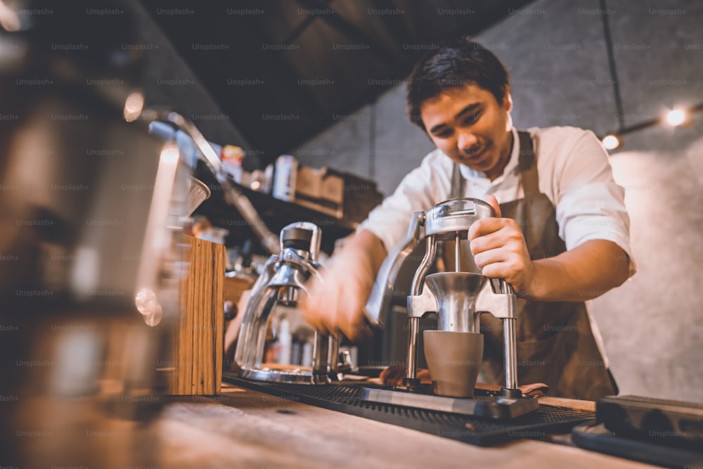 Professioneller Barista macht heißes Getränk Espresso schwarzer Kaffee auf Vintage-Holztisch langsame Bar im Café, Koffein zu einer Glastasse am Morgen brauen, Filtertropfen Getränke Kaffeestil, Hipster-Lebensstil