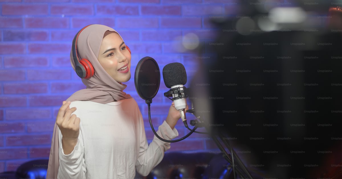 A young smiling muslim female singer wearing headphones with a ...